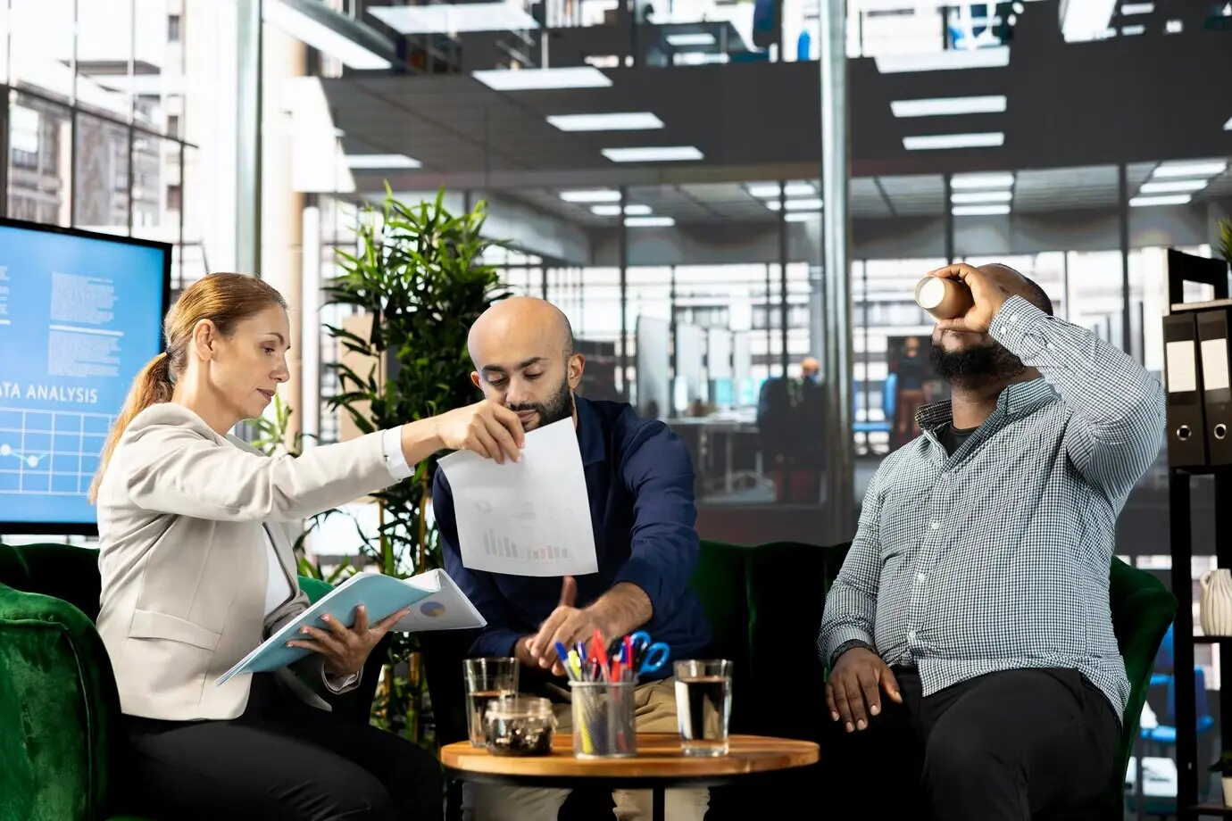 Бухгалтеры изучают цифры выручки в документах в офисе.